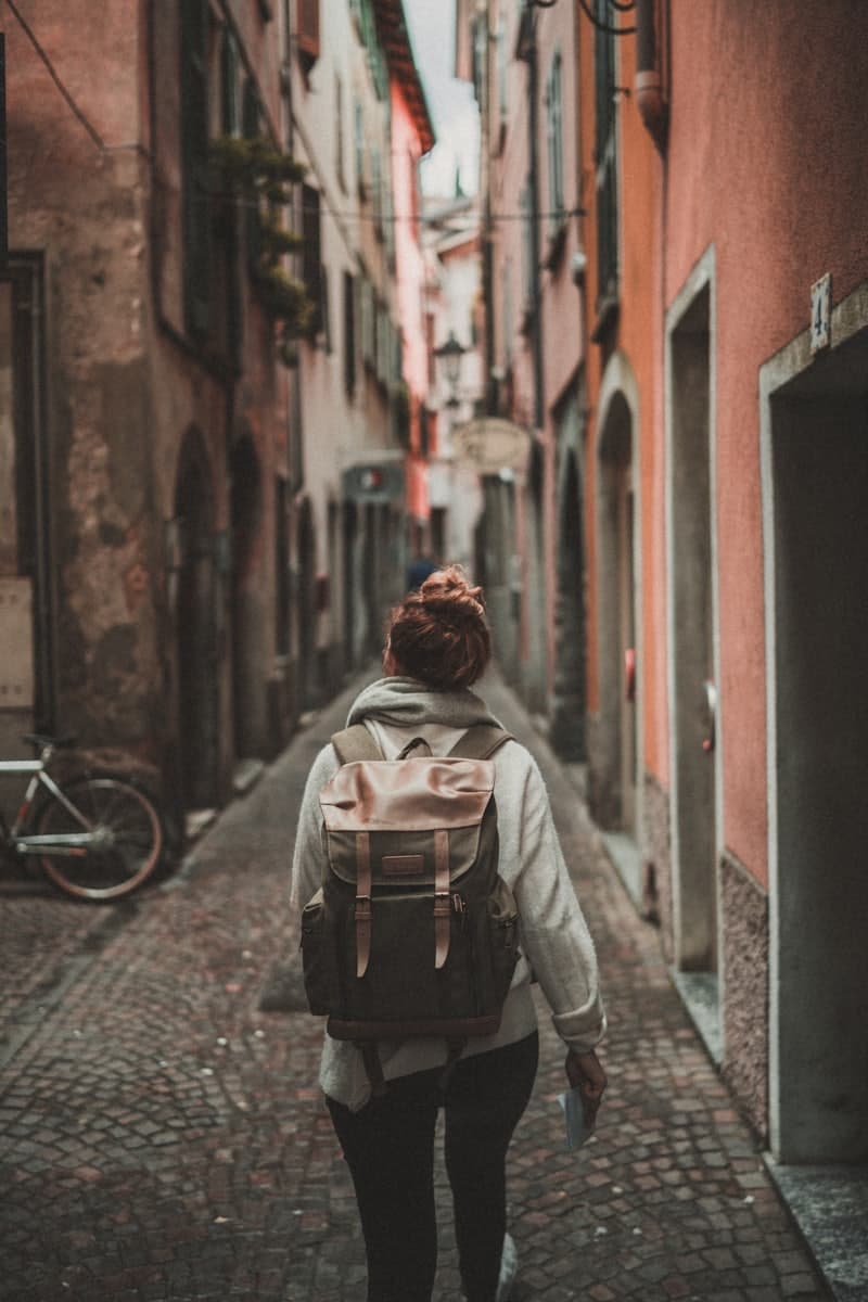A traveler wandering a terracotta alleyway
