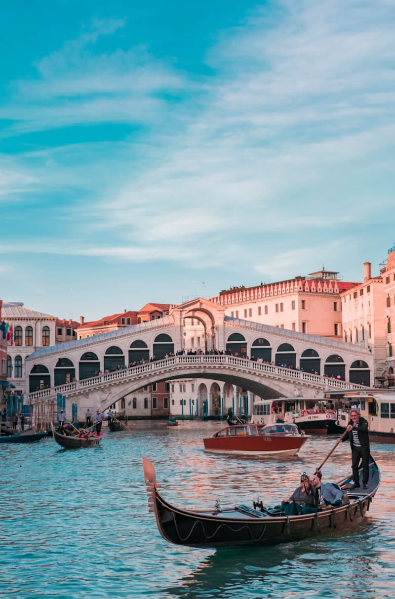 A gondola gliding past the Rialto bridge