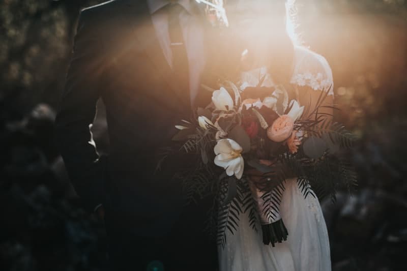 A couple with a bouquet in warm backlight
