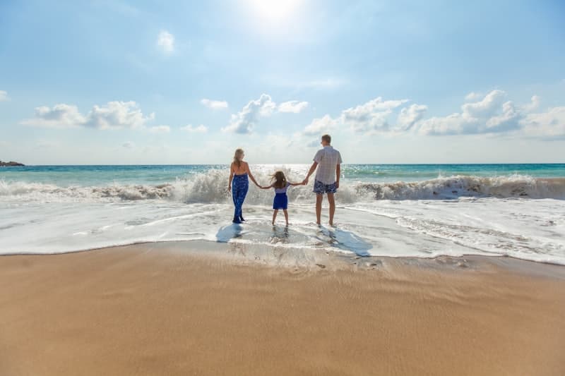 A family holding hands in the surf